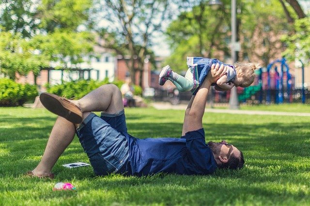 father and child lying on the grass prepared by Cardiff landscaping